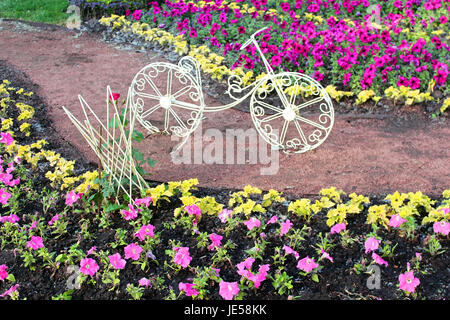 Bicicletta decorativo su un letto di fiori Foto Stock