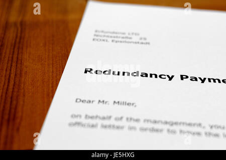 Una lettera su una tavola di legno - pagamento di ridondanza Foto Stock