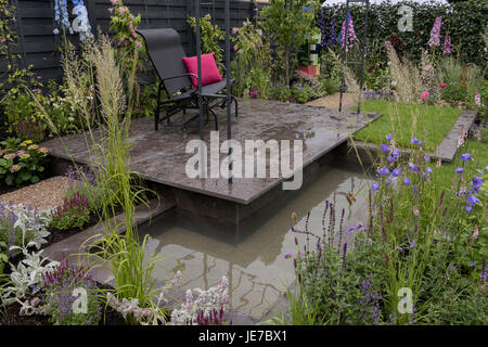 Il sedile rialzato & pond in & modernista di ispirazione Bauhaus Agriframes giardino al primo RHS Chatsworth Flower Show - Chatsworth House, Derbyshire, Inghilterra, Regno Unito. Foto Stock