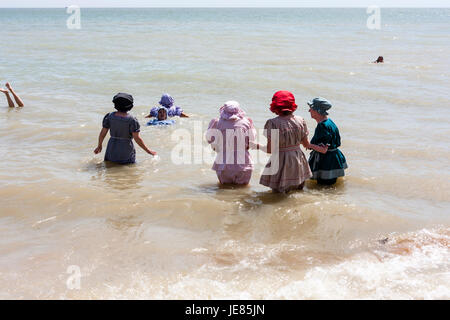 Broadstairs Dickens settimana, Vittoriano beach party. Gruppo di persone, soprattutto per gli anziani, per bambini sulla riva del mare sui principali sands. Vestiti in stile vittoriano costumi da bagno. Cielo azzurro e sole splendente. Foto Stock