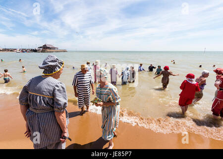 Broadstairs Dickens settimana, Vittoriano beach party. Gruppo di persone, soprattutto per gli anziani, per bambini sulla riva del mare sui principali sands. Vestiti in stile vittoriano costumi da bagno. Cielo azzurro e sole splendente. Foto Stock