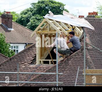 Costruttori di costruire un soppalco interno in un bungalow suburbana England Regno Unito Foto Stock