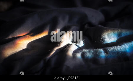 Rifrange la luce del sole attraverso le increspature si piega in una coperta. Foto Stock