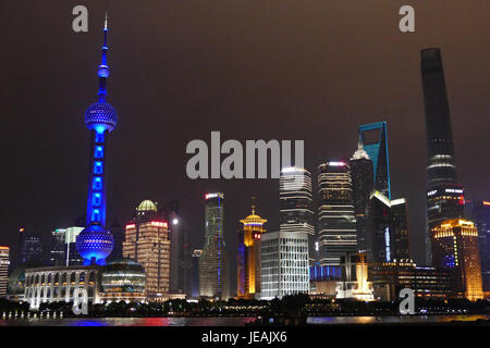 Questa fotografia cattura una splendida vista notturna di Pudong, Shanghai, con il Bund in primo piano. Il paesaggio urbano è illuminato da luci vibranti che si riflettono sul fiume Huangpu. Lo skyline presenta grattacieli moderni, che simboleggiano la rapida crescita e il significato economico di Shanghai nel XXI secolo. Foto Stock