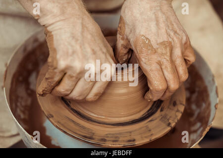 Close up dei maschi di artigiano lavorando sulla ruota di vasai Foto Stock