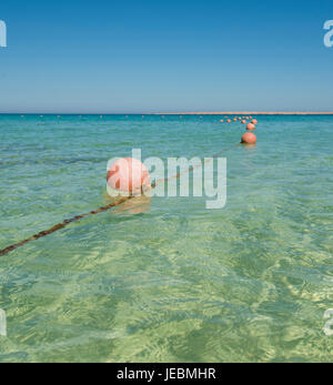 Linea di galleggianti Boe arancione sulla fune nella laguna di spiaggia tropicale oceano mare Foto Stock