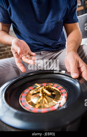 Giovane uomo con la ruota della roulette. giovani avente il concetto di divertimento Foto Stock