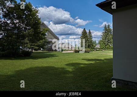 Due case a un piano sono situati uno di fronte all'altra. Tra le case è un verde prato su cui l'erba cresce. Russia, Pskov Regione, natura Foto Stock