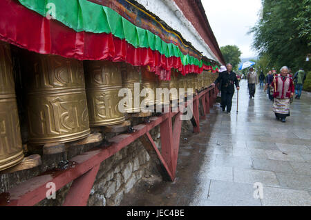 Pellegrini touch mulini di preghiera davanti al palazzo del Potala a Lhasa, in Tibet, Asia Foto Stock