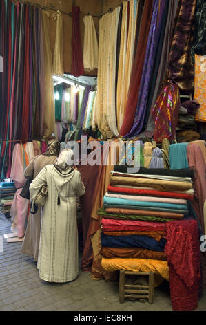 Il Marocco Marrakech, Souk, vendite, sostanze, donne, fare acquisti, Africa, Nord Africa, destinazione, luogo di interesse, cultura, commercio, commercio al dettaglio, economia, mercato, prodotti tessili, sostanza balle, sostanza traiettorie, persone locali, caftan, vista posteriore, stand, Foto Stock