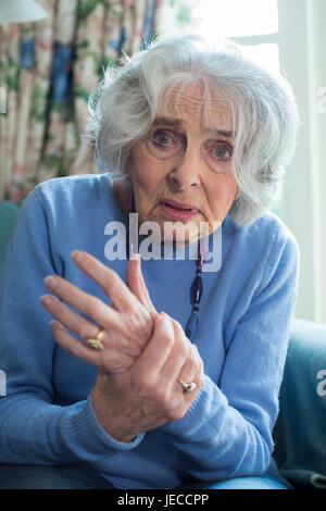Senior donna a casa la sofferenza con artrite Foto Stock