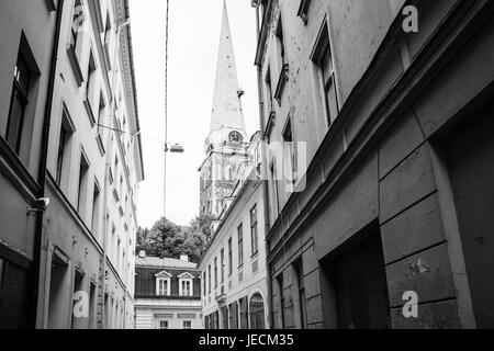 Il viaggio per la Lettonia - case urbane su Maza Miesnieku iela street e la vista della torre di St James's Cathedral (Basilica Cattedrale di San Giacomo a Riga ci Foto Stock