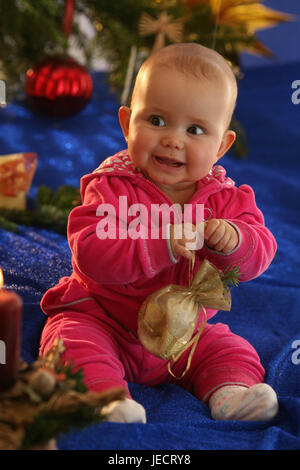 Baby, 6 mesi, sedersi, albero di Natale, skyer, presenta grandi occhi, Foto Stock