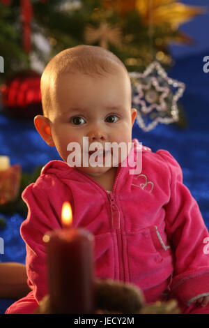 Baby, 6 mesi, sedersi, albero di Natale, skyer, presenta grandi occhi, Foto Stock