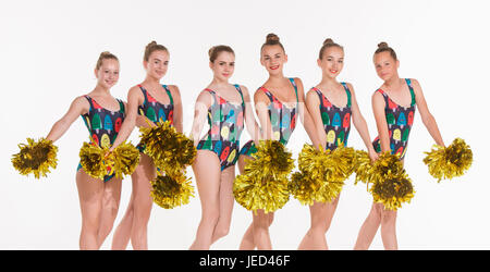 Il gruppo di teen cheerleaders che pongono a white studio Foto Stock