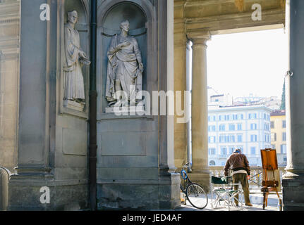 Firenze, Italia - JUNUARY 12, 2009: Statue di Amerigo Vespucci e Francesco Guicciardini vicino al Corridoio Vasariano e l'artista di strada sul lungomare di Arn Foto Stock
