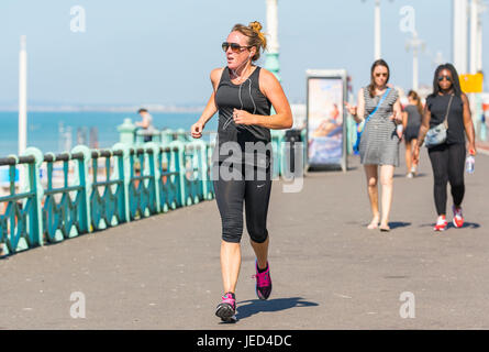 Giovane donna fare jogging lungo il lungomare in un caldo giorno d'estate. Foto Stock