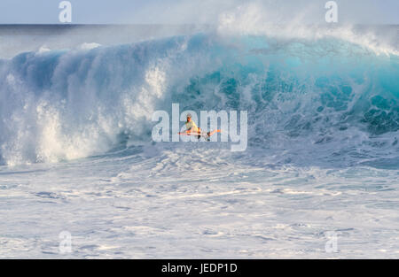 Oahu Hawaii, estremo del corpo boarder cavalca un gigantesco oceano onda sulla costa sottovento di Oahu Hawaii Foto Stock