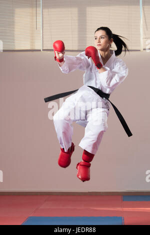 Giovane donna di mettere in pratica il suo Karate si muove - Bianco Kimono - Cintura nera Foto Stock