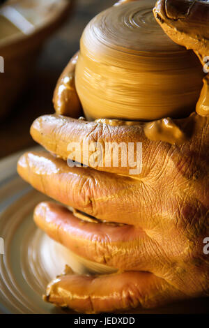 Le mani di un vasaio, creazione di un vaso di terracotta sul cerchio Foto Stock