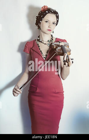 La giovane violinista donna con violino in mani su uno sfondo bianco. Ritratto in studio Foto Stock