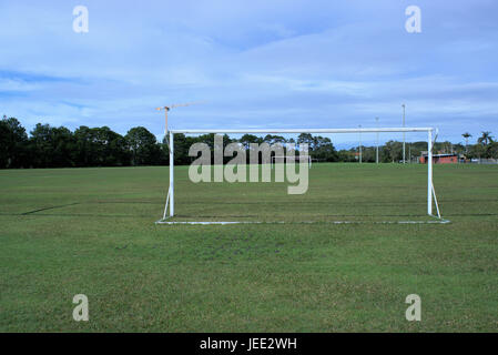 Parco giochi di calcio in Australia. Parco giochi di calcio con pali, proiettori, alberi e una gru in lontananza. Foto Stock