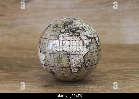 Una sfera o globo del mondo che ha un vintage e vecchio stile guarda su un sfondo di legno. Foto Stock