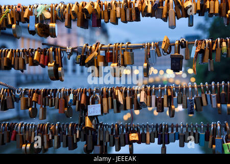 Close up di amore si blocca su di macellerie bridge al tramonto con le luci del triplo ponte sul fiume Ljubljanica canal in background Ljubljana Slovenia Foto Stock