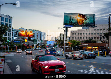 Il Sunset Strip al crepuscolo con cartelloni pubblicitari illuminati promuovere il film Wonder Woman a Los Angeles, CA. Foto Stock