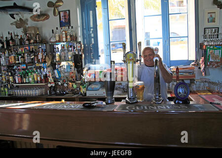 Barman tirando pinte di birra all'interno di Gleneagles Bar pub a Mgarr a Gozo, Malta Foto Stock