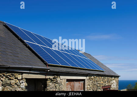 Pannello solare sul tetto in ardesia, cielo blu sullo sfondo,Anglesey,il Galles del Nord,Regno Unito.Pannello solare inclinato sul tetto della casa, Uk.cella solare. Foto Stock