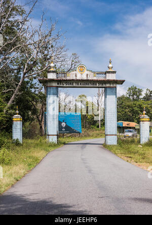 Il Karnataka, India - 26 Ottobre 2013: azzurro benvenuti gate sulla linea di stato con il Tamil Nadu a Bandipur riserva della tigre e il National Forest. Cielo blu Foto Stock