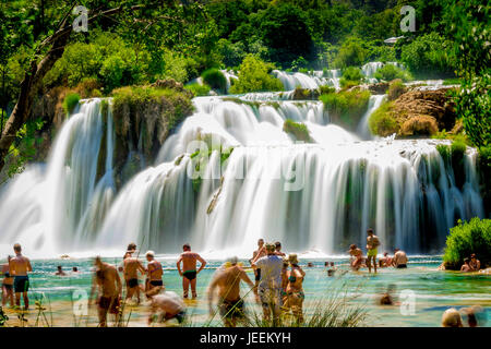 I turisti nuotano sotto la cascata di Skradinski buk al Parco Nazionale di Krka in Croazia Foto Stock