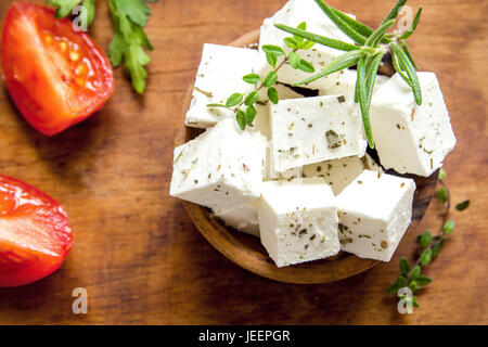 Greco fresco formaggio Feta. Ingrediente sano per la cottura di insalata. Caprino formaggio feta con erbe aromatiche. Foto Stock