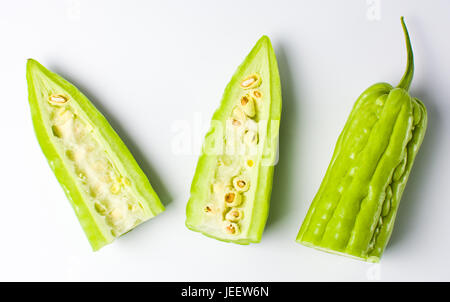 Tagliate a fette di melone amaro gourd su sfondo bianco Foto Stock