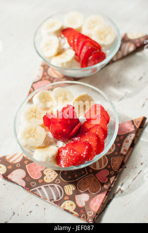 Due ciotole di ricotta con fragole e banane. Close-up, il fuoco selettivo. Foto Stock