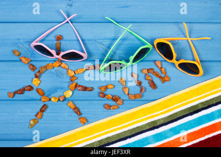 Forma di Sun con word sun fatta di pietre color ambra e accessori per le vacanze e per l'estate Foto Stock