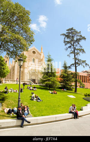 Madrid, Spagna - 19 Aprile 2013: persone rilassarsi sul prato vicino al museo El Prado e San Girolamo Royal Chiesa. Foto Stock