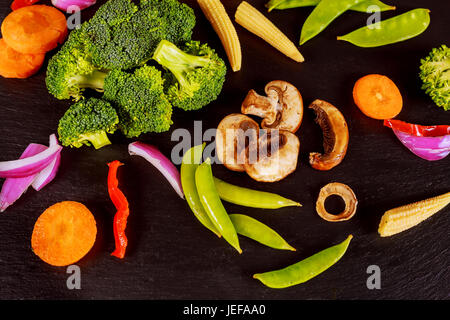 Verdure verdi sul tavolo in pietra nera, Foto Stock