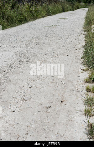 Pista sterrata che conduce in lontananza - metafora visiva per numerosi canti sulle strade. Lunga strada avanti, fine della metafora della strada. Foto Stock