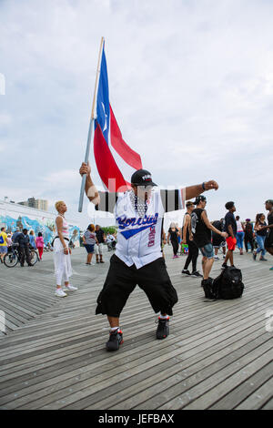 Il Puerto Rican persone celebrando con Puerto Rico bandiere in Coney Island boardwalk durante il fine settimana estivo, Brooklyn, Stati Uniti d'America Foto Stock