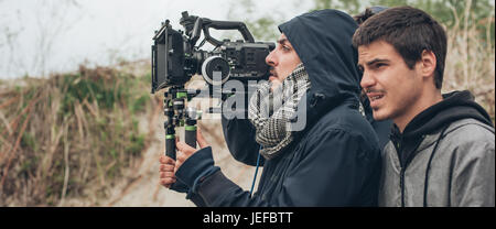 Dietro la scena. Cameraman e regista di film di scatto scena sulla posizione esterna Foto Stock