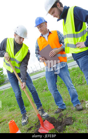 Lavoratori fisica con la pala e il casco di sicurezza Foto Stock