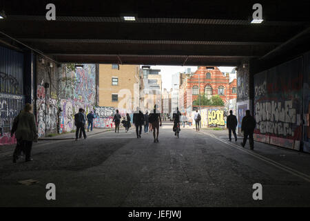 La mattina presto i pendolari a piedi verso la città da Shoreditch High Street station in Spitalfields vicino a Whitechapel, Londra Foto Stock