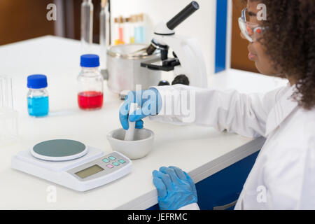Donna scienziato utilizzando mortaio lavorando nel laboratorio di rendere i prodotti chimici in polvere per esperimento, ricercatore gara Mix Foto Stock