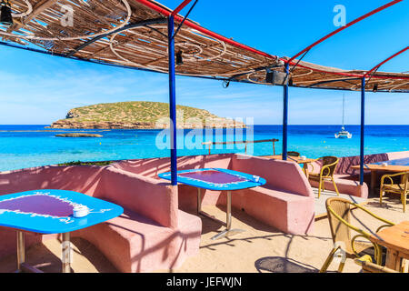 Tabelle nel ristorante costiere su Cala Comte beach, isola di Ibiza, Spagna Foto Stock