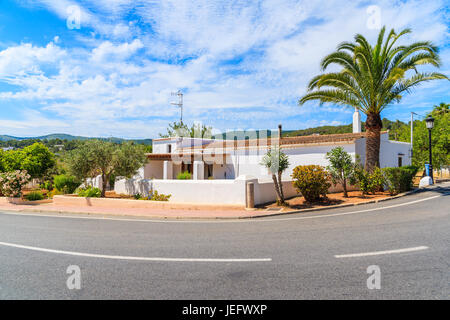 Tipica casa bianca con Palm Tree sul lato di una strada in Sant Carles de Peralta village, isola di Ibiza, Spagna Foto Stock