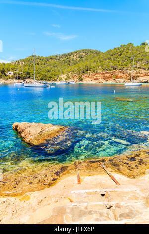 Barche a vela blu acqua di mare a Cala Salada bay, isola di Ibiza, Spagna Foto Stock