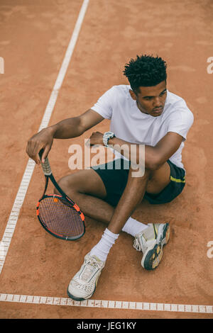 Vista superiore giovane giocatore di tennis si trova sul terreno di un campo da tennis Foto Stock