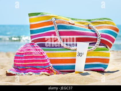Bottiglia di crema di protezione solare sulla spiaggia sabbiosa. Foto Stock